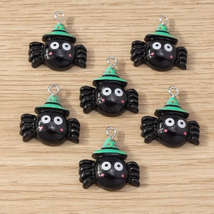Macro shot of 6 black resin spider pendants with green wizard hats for DIY jewelry