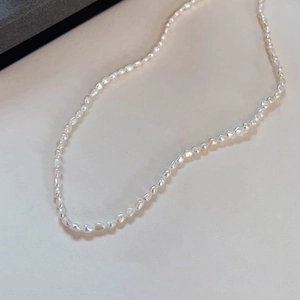 Detail shot of baroque freshwater pearls on soft beige fabric background with natural shine