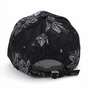 Close-up of black lace baseball cap featuring intricate mesh and silver metal buckle