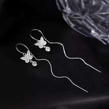 Vue macro de boucles d'oreilles papillon en argent avec zircons sur velours noir