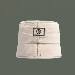 Beige canvas bucket hat with contrast black stitching and embroidered logo for sun protection