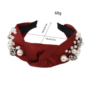 Red knotted pearl headband for women featuring white beads and stylish fabric finish