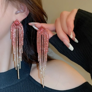 Close-up of elegant gradient pink tassel earrings with sparkling rhinestones on model
