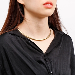Close-up of a 6mm gold plated stainless steel flat snake chain necklace on a model's neck
