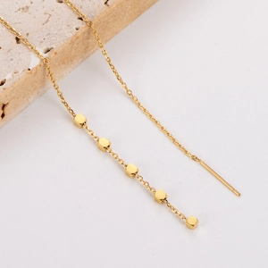 Detailed view of elegant gold stainless steel tassel chain earrings on stone