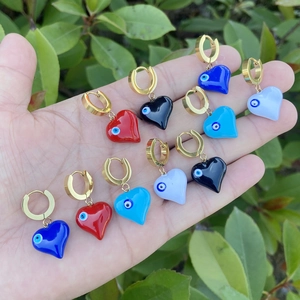 Golden heart earrings set with colorful evil eye patterns in blue, red and white