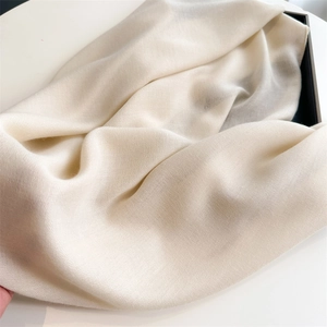 Close-up texture of beige cotton linen scarf showing soft fabric weave and detail