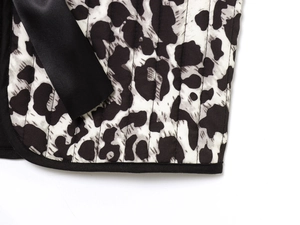 Close-up of leopard print quilted vest with black satin ribbon and fine stitching