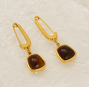 Detailed view of 18K gold earrings featuring unique deep brown natural stone drops