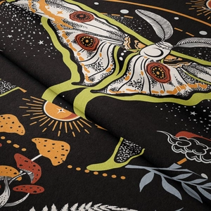 Detailed close-up of bohemian tapestry fabric showing moth, moon, and floral patterns