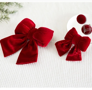 Detailed view of red velvet bow decorations in large and small sizes for holiday decor
