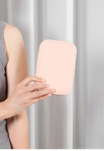 Pink PU leather portable jewelry box with stitching detail held in hand for size display