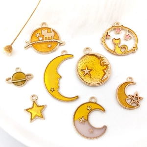 Dettaglio di otto ciondoli fai-da-te in lega d'oro con smalto luna e stelle per fare gioielli