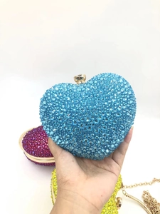 Macro detail of heart-shaped blue rhinestone evening bag with elegant gold clasp