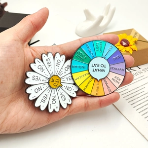 Detailed close-up of rainbow metal pins featuring a spinning food wheel and a daisy charm