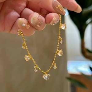 Elegant gold chain bracelet with transparent heart charms and sparkling zircon details