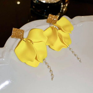 Detail view of floral earrings with yellow petals, pearl tassels and hammered gold studs