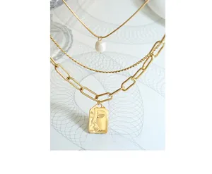 Detail view of triple-layered gold chain necklace with freshwater pearl and face pendant