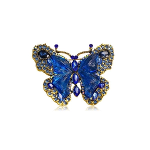 Detail of blue crystal butterfly brooch with deep blue rhinestones and gold plating