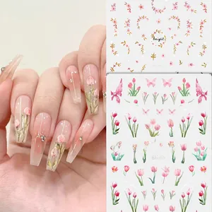 Macro detail of tulip and butterfly nail stickers with gold accents and lettering