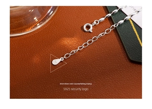 Macro shot of S925 sterling silver lobster clasp and hallmark on grain leather