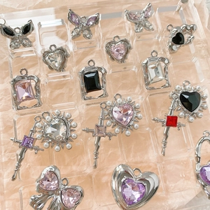 DIY jewelry charm kit with silver metal butterflies, hearts and pearls in a storage tray