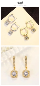 Macro shot of square silver earrings with round halo-set cubic zirconia in gold and silver