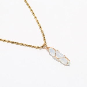 Close-up of a white crystal pillar pendant with gold wire wrapping on a twisted rope chain