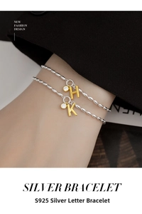 Detailed shot of S925 silver beaded bracelets featuring gold letter H and K charms with zircons
