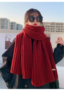 Detail of red knitted winter scarf showing thick texture and soft warm material