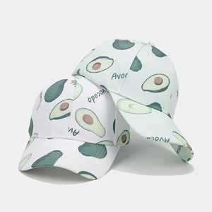 Close-up of white and green baseball caps with realistic avocado print and Avocado text
