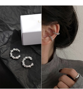 Close-up of textured silver ear cuffs and matching ring with irregular crushed silver finish