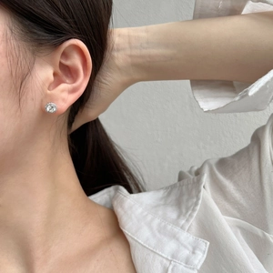 Close-up of S925 sterling silver stud earring with clear zircon inlay on female ear