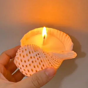 Macro shot of a lit shell scented candle with natural texture and warm orange flame