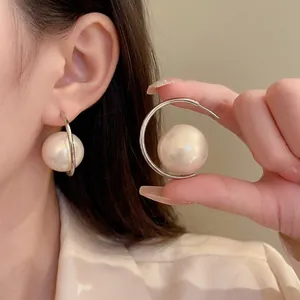Elegant C-shaped silver earrings with a large 18mm high-luster pearl in a minimalist design