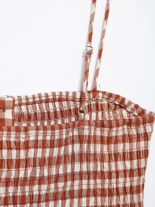 Detail of brown gingham smocked bodice and adjustable spaghetti strap on cropped top