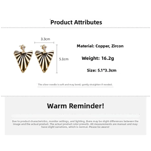 Vue détaillée de boucles d'oreilles éventail émaillées noir et blanc avec fini doré