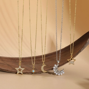 Close-up of star, moon, and pearl pendants with zircon inlays on delicate chains