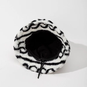 Black and white striped faux fur bucket hat with warm plush texture for winter style