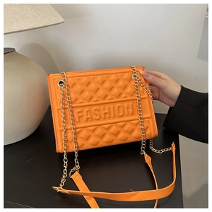 Detail of orange quilted faux leather shoulder bag with golden chain and fashion logo