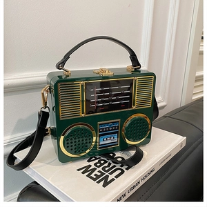 Detail of vintage dark green radio shaped acrylic bag with gold metal hardware and latch