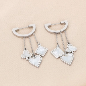 Close-up of dangling poker symbols with white mother of pearl inlay on silver earrings