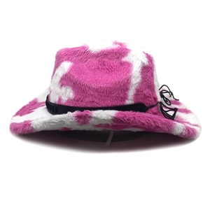 Detalle del sombrero de vaquero de felpa rosa con estampado de vaca y cordón negro decorativo