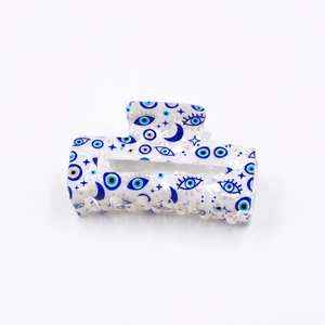 Translucent white PVC hair claw clip with blue evil eye and gold star patterns