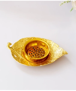 Detailed macro view of leaf-shaped golden incense burner base with fine metal vein texture