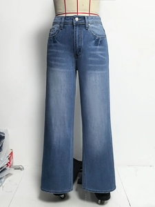 Detail van high-waist jeans met wijde pijpen en vintage wassing op blauw denim materiaal