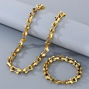 Detailed shot of golden hollowed bamboo link chain necklace and bracelet set in stainless steel
