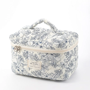Quilted cotton makeup bag with blue floral pattern and convenient carry handle