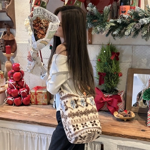 Detail of plush bucket bag featuring Nordic snowflake patterns in a cozy winter setting