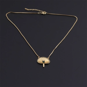 Collier pendentif éventail plaqué or avec pierre verte et zircons sur fond noir